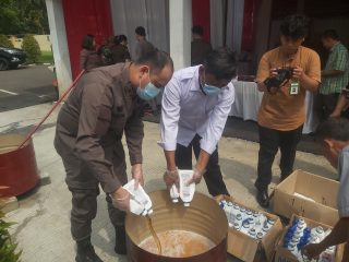 Kepala Seksi Pidana Umum Kejaksaan Negeri Kabupaten Tangerang, Malda (kiri), saat Memusnahkan Barang Bukti Oli Palsu.
