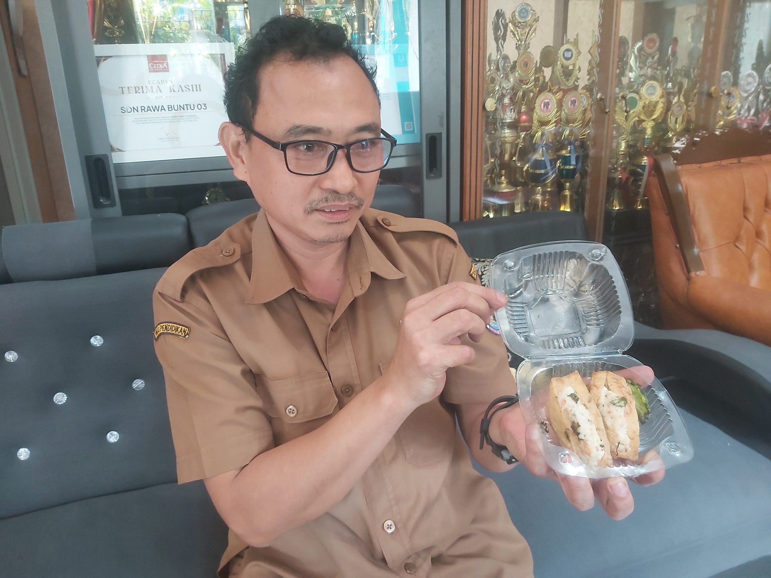 Kepala Sekolah SDN 03 Rawa Buntu Tangsel, Amir Mahmud saat menunjukan tahu isi yang diterima sebagai menu MBG.