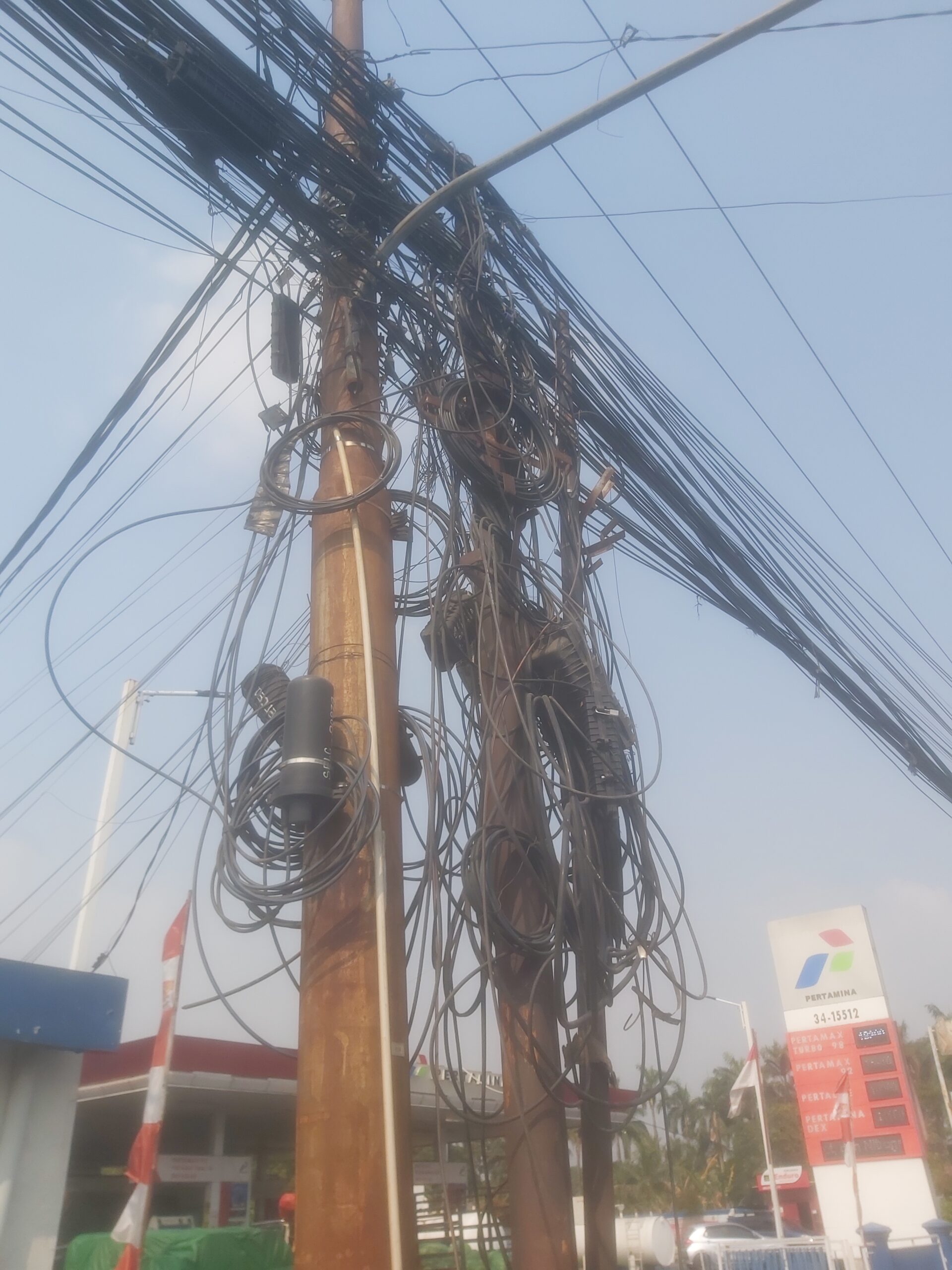 Salah satu tiang telekomunikasi dengan kondisi kabel semraut di Jalan Raya Pasar Kemis, Kuta Jaya. (khi)