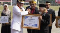 Bupati Tangerang Moch. Maesyal Rasyid menyerahkan piagam penghargaan kepada penerima penghargaan dalam rangkaian peringatan HUT ke-81 Kemerdekaan RI di Puspemkab Tangerang, Senin (17/8/2026).
