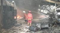 Petugas pemadam kebakaran menyemprotkan air ke arah puing-puing gudang yang roboh dan masih menyisakan titik api di kawasan pergudangan Jatiuwung, Kota Tangerang. Banyaknya material mudah terbakar seperti kardus, garmen, dan bahan sepatu membuat proses pemadaman membutuhkan penanganan ekstra